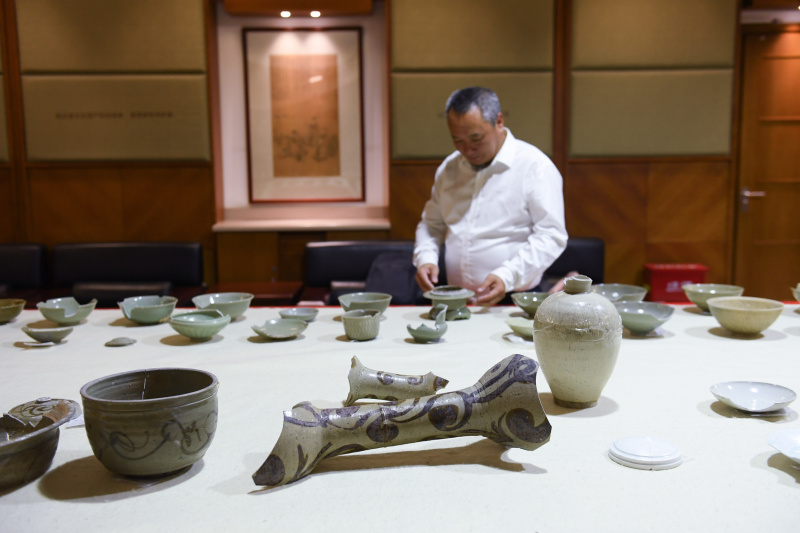 Un chercheur examine des céramiques découvertes sur le site archéologique de l'ancien port de Shuomen à Wenzhou