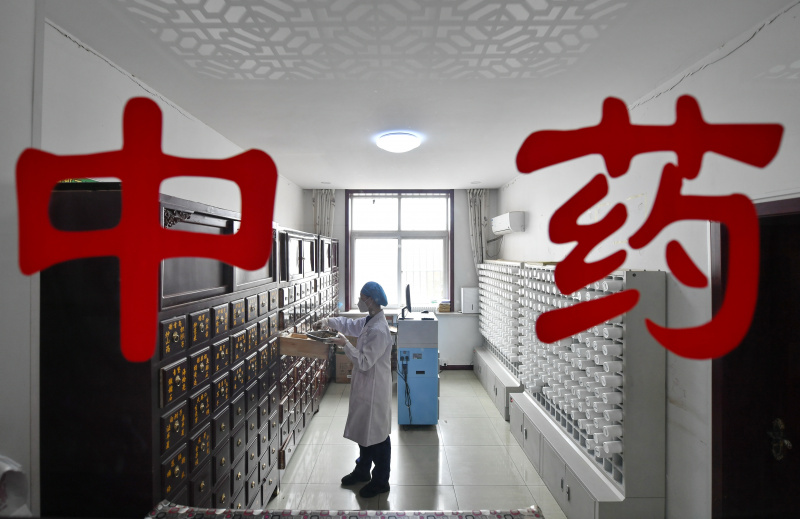 Une pharmacienne dispense des médicaments traditionnels chinois dans un centre de santé du bourg de Huanggezhuang de l'arrondissement de Fengnan