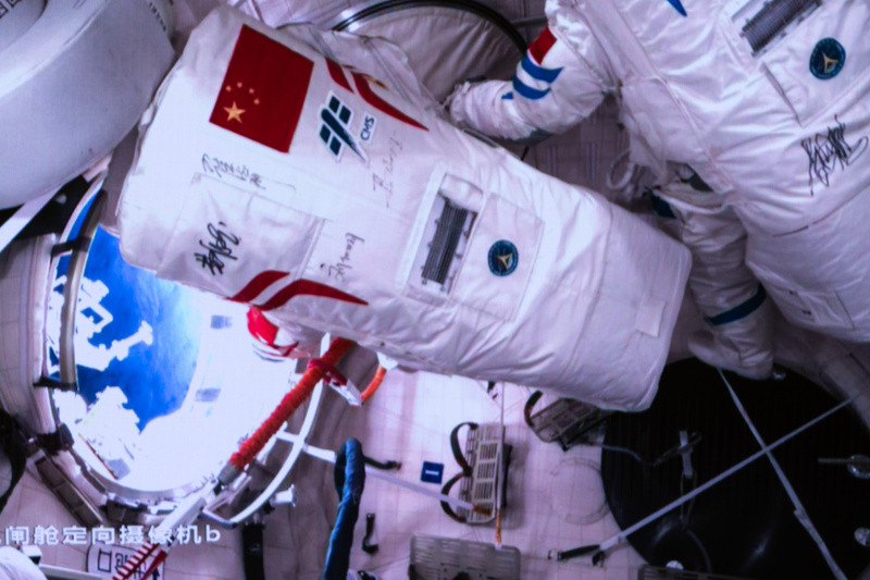 Image d'écran capturée au Centre de contrôle aérospatial de Beijing de l'astronaute de Shenzhou-17 Tang Hongbo (à gauche) ouvrant la trappe du sas de la cabine du module laboratoire Wentian de la station spatiale