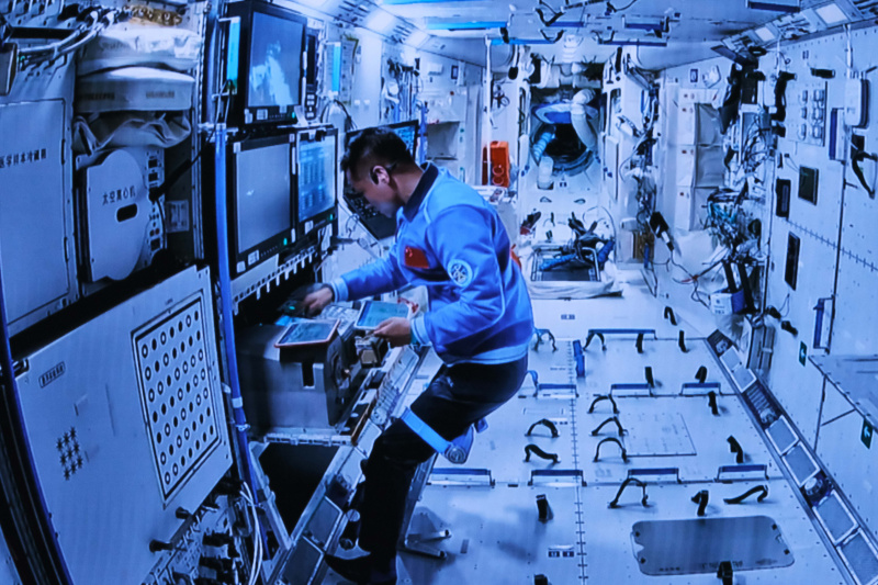 Image d'écran capturée au Centre de contrôle aérospatial de Beijing montrant l'astronaute de Shenzhou-17 Jiang Xinlin à l'intérieur du module laboratoire coopérant avec Tang Hongbo et Tang Shengjie pour leurs activités extravéhiculaires