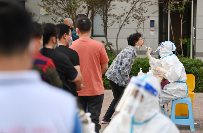 Des habitants font la queue pour des tests d'acide nucléique dans une zone résidentielle de l'arrondissement de Xiqing