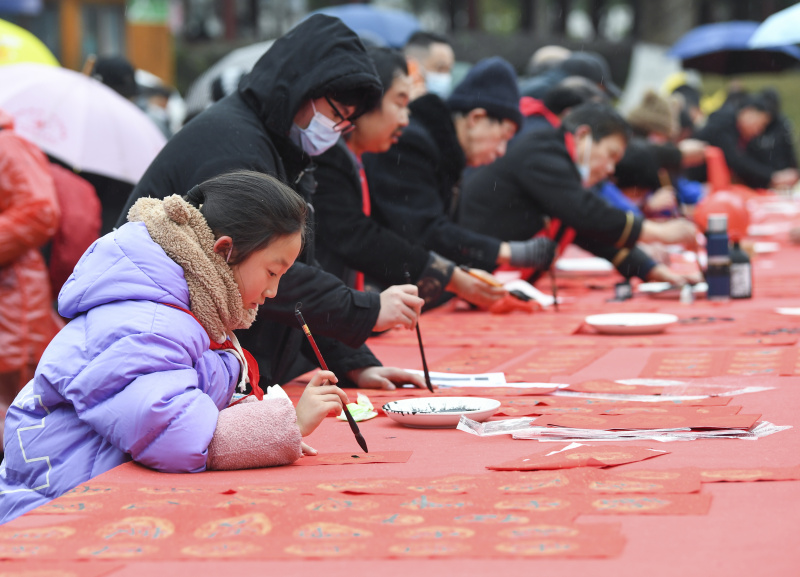 Des gens participent à une activité de composition de couplets de la fête du Printemps dans l'arrondissement de Yongchuan