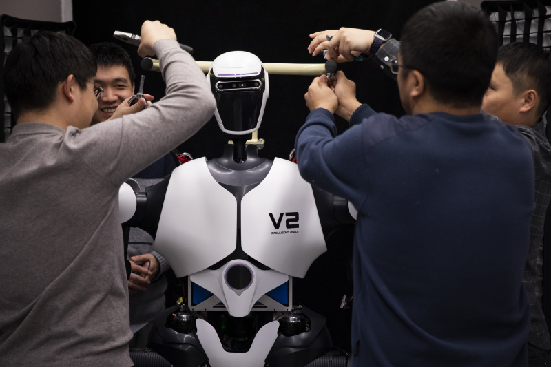Des chercheurs ajustent un robot humanoïde dans un laboratoire d'intelligence artificielle le 31 janvier 2024