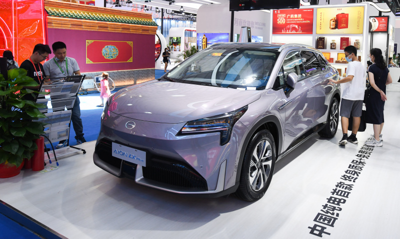 Des visiteurs examinent une voiture électrique à la deuxième Exposition internationale des produits de consommation de Chine
