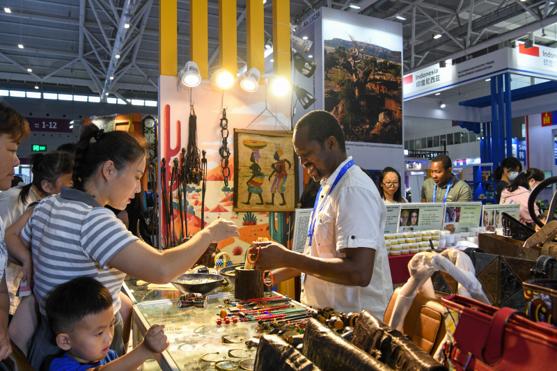Des visiteurs achètent des produits sur un stand du Mali lors du 19e salon international des industries culturelles de Chine à Shenzhen