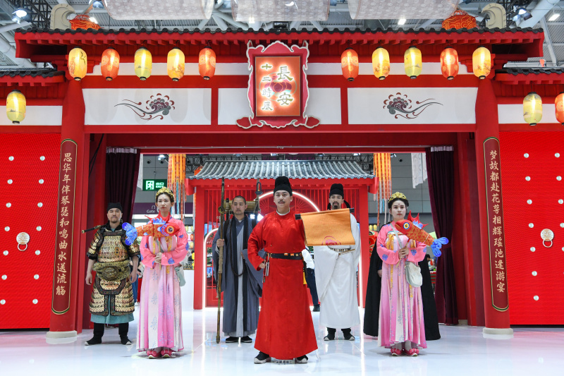 Des employés habillés en costumes anciens du stand du Shaanxi de la Chine accueillent les visiteurs lors du 19e salon international des industries culturelles de Chine