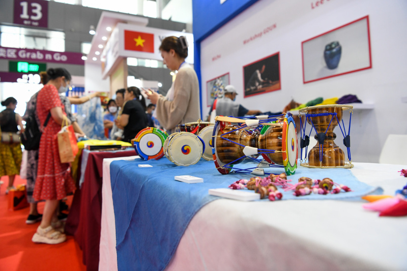 Des visiteurs achètent des produits sur un stand lors du 19e salon international des industries culturelles de Chine à Shenzhen