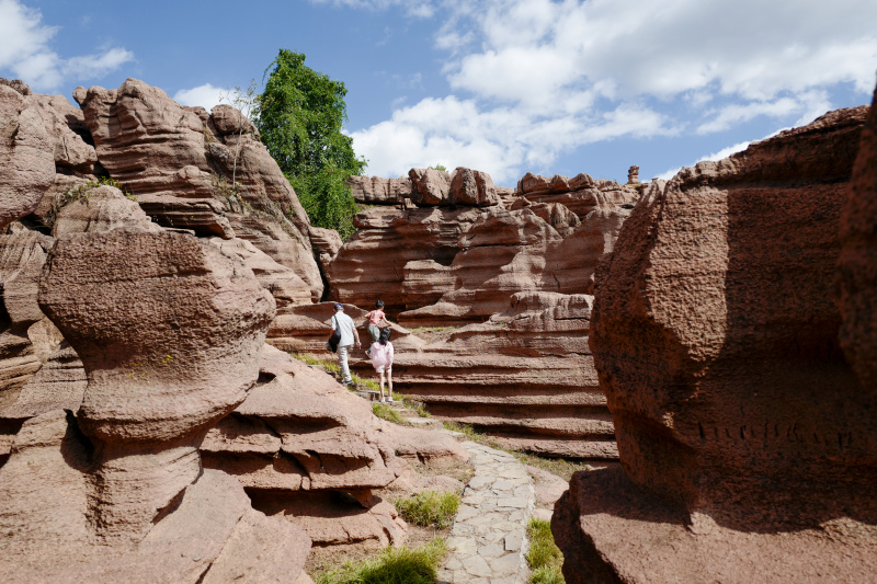 Des touristes visitent un géoparc forestier de roches rouges dans le district autonome Tujia et Miao de Youyang