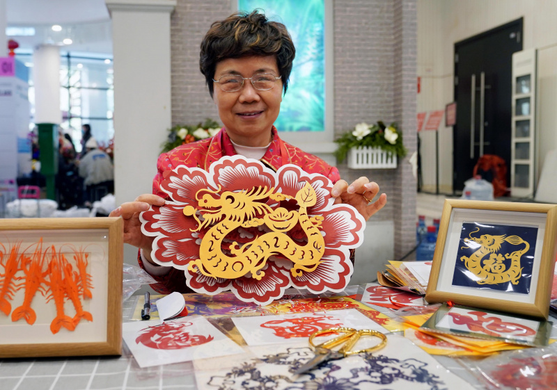 Une artisane présente une de ses pièces en papier découpé lors d'une exposition sur les coutumes du Nouvel An lunaire chinois