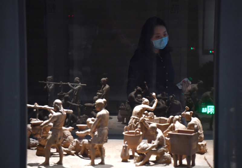 Une femme visite un musée présentant des vestiges de la dynastie Shang (1600-1046 av