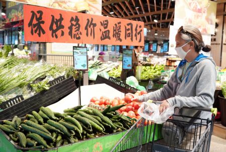 (miniature) Une habitante achète des légumes dans un supermarché de l'arrondissement de Haidian à Beijing