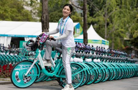 (miniature) Une bénévole sur un vélo partagé décoré en l'honneur de l'Universiade de Chengdu