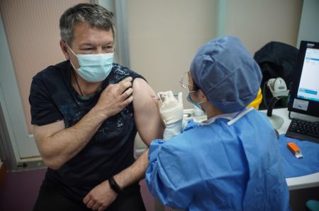 (miniature) Un étranger reçoit une dose de vaccin contre la COVID-19 dans un site de vaccination de Beijing
