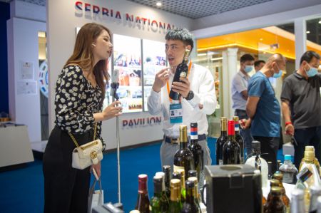 (miniature) Un exposant (deuxième à gauche) fait la promotion de produits vinicoles en provenance de Serbie