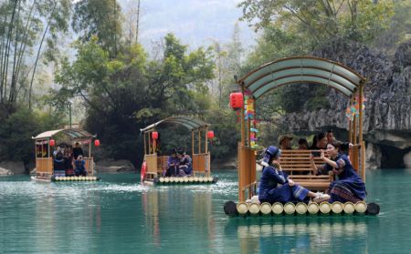(miniature) Des visiteurs prennent des radeaux en bambou pour admirer le paysage du site touristique de Daxiaojing dans le district de Luodian