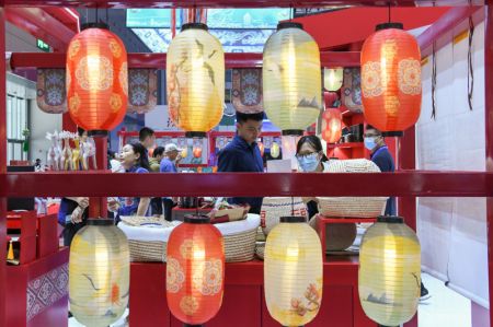 (miniature) Des visiteurs choisissent des produits sur le stand du Shaanxi de la Chine lors du 19e salon international des industries culturelles de Chine