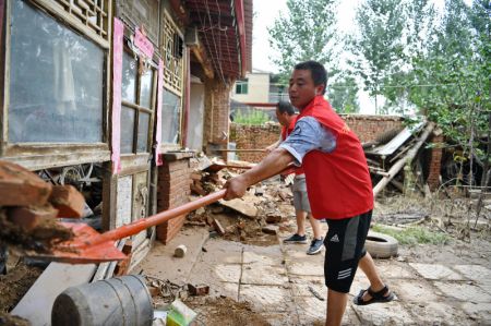 (miniature) Des bénévoles participent à l'évacuation des débris d'une cour inondée dans le bourg de Diaowo à Zhuozhou