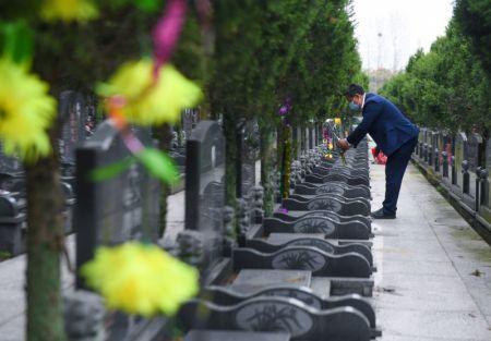 (miniature) Un employé rend hommage aux défunts au nom des personnes en deuil dans un cimetière à Huzhou