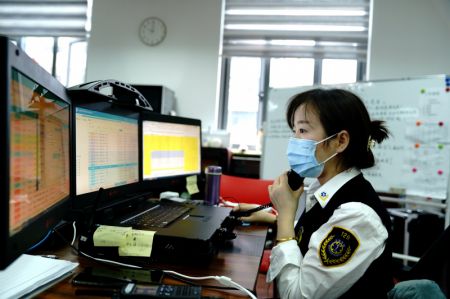 (miniature) Une membre du personnel parle au téléphone pour envoyer des ambulances au centre d'urgence de l'arrondissement de Minhang