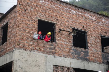 (miniature) Des ouvriers examinent et fixent des lignes électriques sur les lieux d'un accident de mine de charbon dans le district de Yongchuan