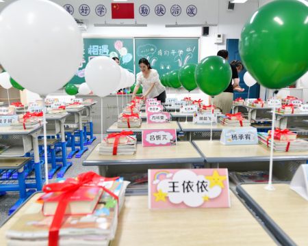 (miniature) Une enseignante organise la salle de classe pour les élèves de première année à l'école primaire de Mingjing