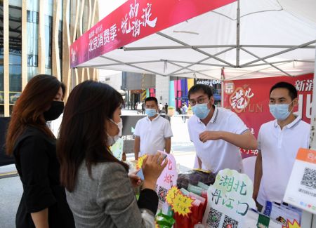 (miniature) Des employés présentent des produits agricoles aux consommateurs lors d'une animation à Beijing
