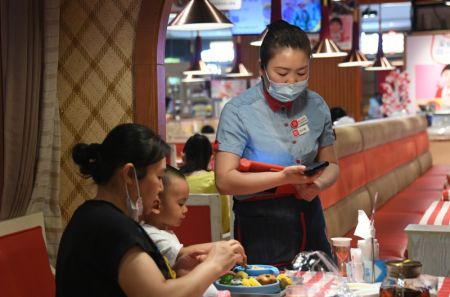 (miniature) Une serveuse sert des clients dans un restaurant à Beijing