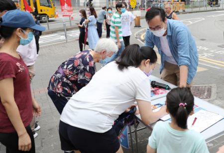 (miniature) Des citoyens signent lors d'une campagne de rue en faveur de la législation sur la sécurité nationale pour la Région administrative spéciale (RAS) de Hong Kong