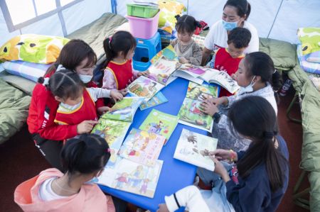 (miniature) Des enseignants apprennent aux enfants à lire dans un abri de secours à la suite du séisme