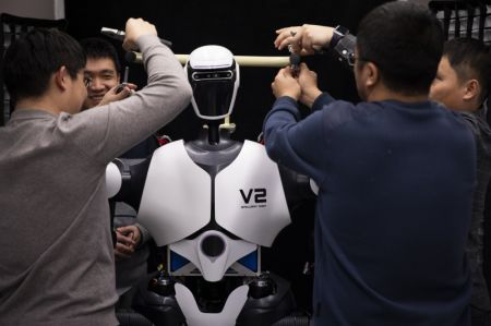 (miniature) Des chercheurs ajustent un robot humanoïde dans un laboratoire d'intelligence artificielle le 31 janvier 2024