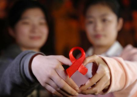 (miniature) Des étudiantes montrent un ruban rouge lors d'un événement de sensibilisation sur le sida à l'Université Nanhua