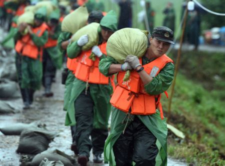 (miniature) Des membres de la police armée renforcent la section de Sanlongwei de la digue dans le bourg de Baimao