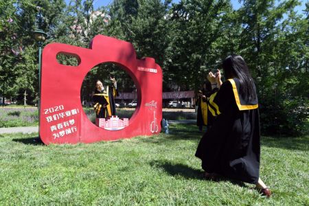 (miniature) Un diplômé de 2020 pose pour des photos sur le campus de l'Université Renmin de Chine