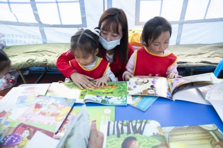 (miniature) Une enseignante apprend aux enfants à lire dans un abri de secours à la suite du séisme
