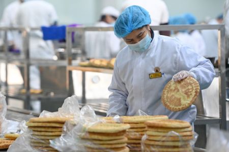(miniature) Un ouvrier trie des pains locaux plats (Nang) nouvellement préparés dans un atelier d'un parc industriel à Horgos