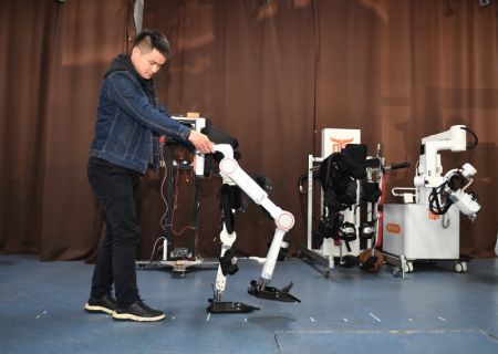 (miniature) Un chercheur du Centre de recherche en robotique de l'Université des sciences et technologies électroniques de Chine examine un exosquelette robotique à Chengdu