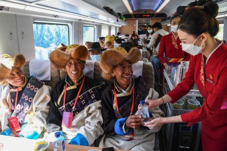 (miniature) Des membres d'équipage servent des passagers dans un train à grande vitesse Fuxing sur le chemin de fer Lhassa-Nyingchi