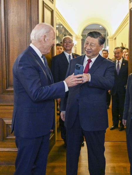 (miniature) Le président américain Joe Biden montre au président chinois Xi Jinping une photo sur l'écran de son téléphone portable à l'entrée d'une salle de banquet du domaine Filoli