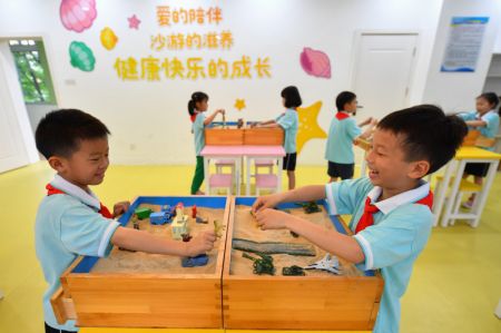 (miniature) Des enfants jouent avec un bac à sable à l'Ecole primaire expérimentale de l'arrondissement de Yuelu