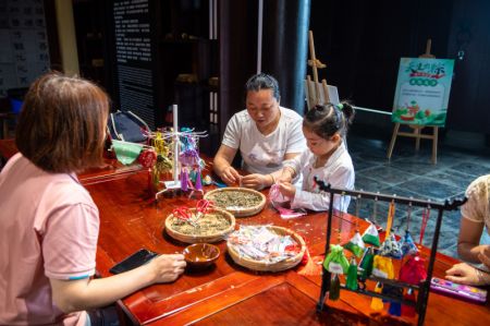 (miniature) Des touristes fabriquent des sachets traditionnels chinois dans un parc culturel de Quzici
