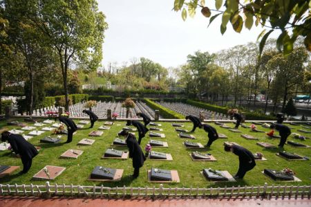 (miniature) Des employés rendent hommage aux défunts au nom des personnes en deuil dans un cimetière à Nanjing