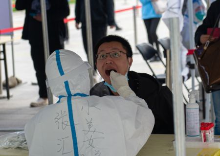 (miniature) Un professionnel de la santé prélève un échantillon sur écouvillon sur un habitant pour un test d'acide nucléique dans le sous-arrondissement d'Aoyuncun de l'arrondissement de Chaoyang