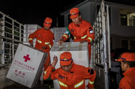 (miniature) Des secouristes transportent du matériel de secours à Yangbi