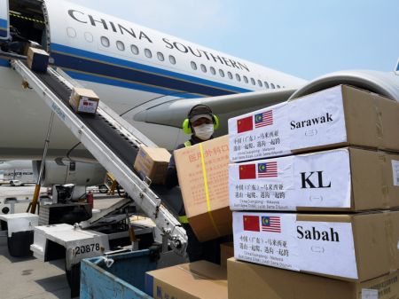 (miniature) Un employé décharge des fournitures médicales apportées par une équipe médicale chinoise anti-COVID-19 envoyée en Malaisie à l'aéroport international de Kuala Lumpur à Sepang