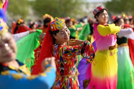 (miniature) Des habitants locaux dansent pour accueillir des touristes dans le bourg d'Awat de la ville de Korla