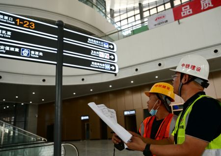 (miniature) Des ouvriers vérifient la mise en place d'une installation dans la salle d'attente de la partie nouvellement construite de la gare du Nord de Xiamen