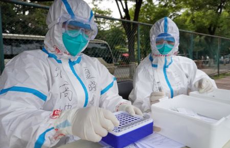 (miniature) Des travailleurs médicaux collectent des échantillons pour des tests d'acide nucléique dans un site de prélèvement de l'arrondissement de Fengtai