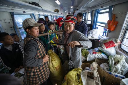 (miniature) Une femme de l'ethnie Yi vend des marchandises dans un marché ambulant à bord du train 5633 dans la province du Sichuan (sud-ouest de la Chine)