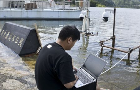 (miniature) Un membre du personnel installe un système de surveillance vidéo pour le niveau d'eau le plus élevé du réservoir de Miyun dans la banlieue de Beijing