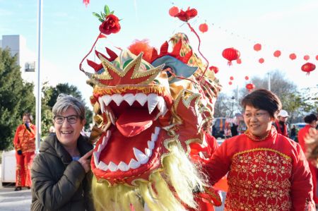 (miniature) Une habitante pose pour une photo avec une danseuse du lion au cours des célébrations du Nouvel An chinois à Madrid